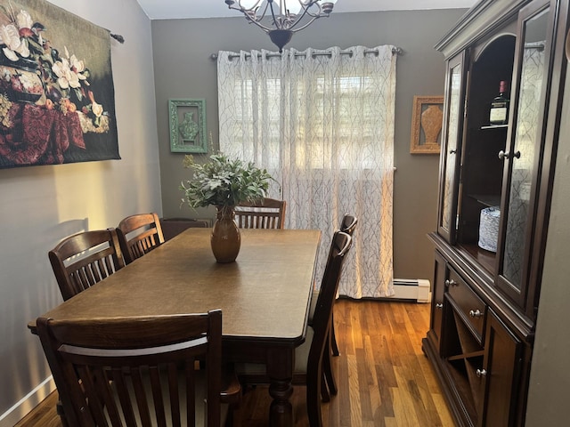 dining room with baseboard heating, an inviting chandelier, and dark wood-style floors