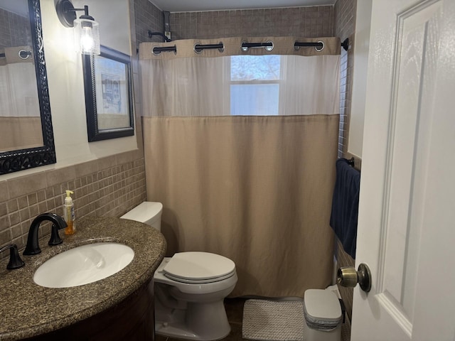 bathroom featuring toilet, a shower with curtain, and tile walls