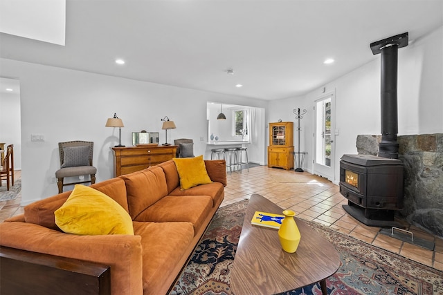 living area featuring a wood stove, tile patterned flooring, baseboards, and recessed lighting