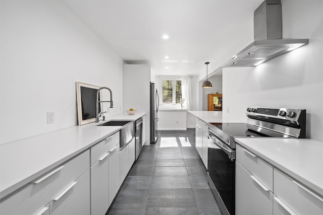 kitchen with light countertops, stainless steel appliances, recessed lighting, and wall chimney exhaust hood