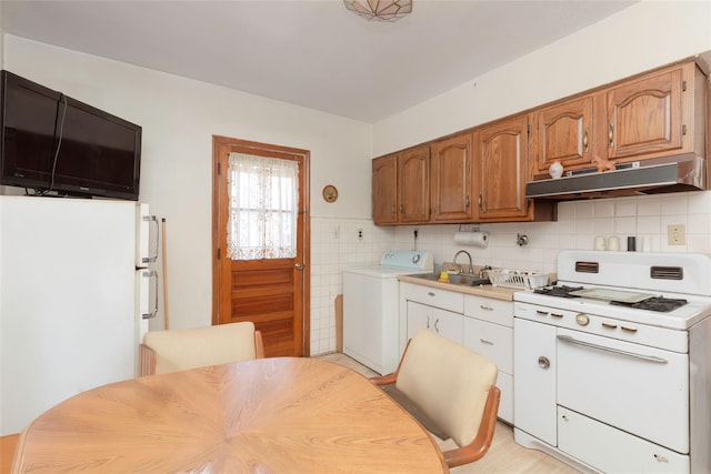 2162 Haight Ave, Bronx, NY 10461 - kitchen featuring a sink, white appliances, washer / clothes dryer, light countertops, and under cabinet range hood