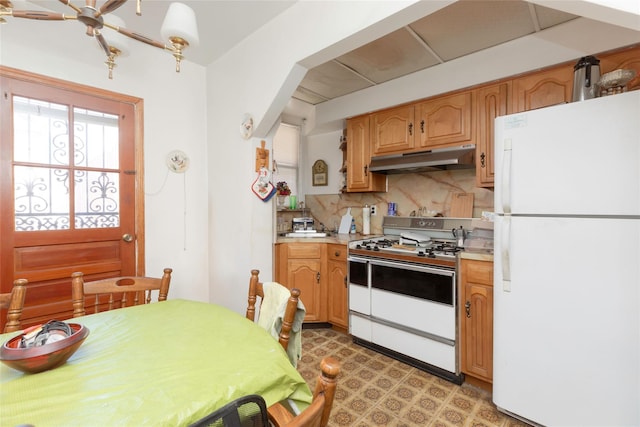 2162 Haight Ave, Bronx, NY 10461 - kitchen featuring under cabinet range hood, light countertops, white appliances, arched walkways, and tasteful backsplash