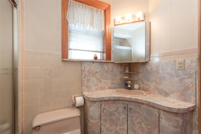 2162 Haight Ave, Bronx, NY 10461 - bathroom featuring a shower with shower door, toilet, vanity, tile walls, and decorative backsplash