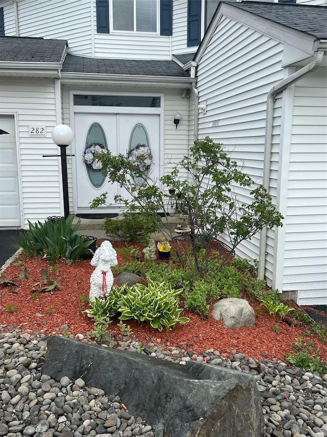 282 Tamerisk Ln, New Windsor, NY 12553 - doorway to property with a garage and a shingled roof