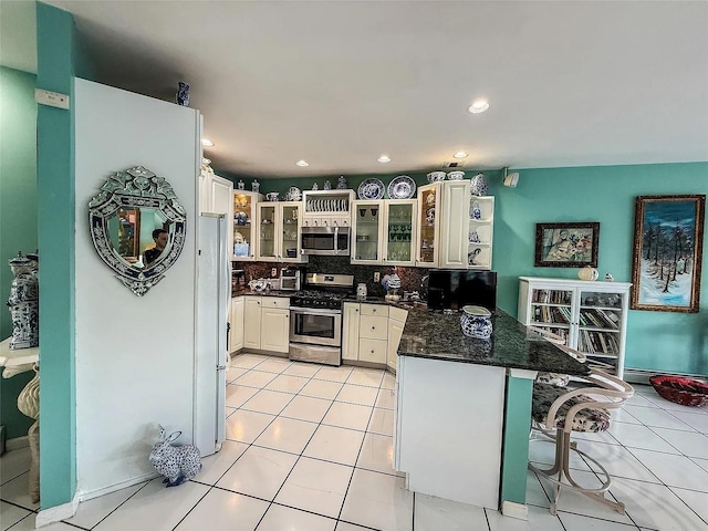 282 Tamerisk Ln, New Windsor, NY 12553 - kitchen featuring appliances with stainless steel finishes, a peninsula, a kitchen breakfast bar, light tile patterned flooring, and recessed lighting