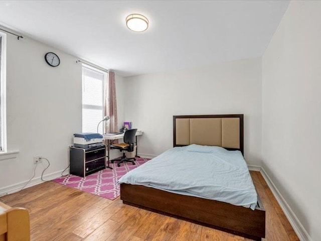 bedroom featuring wood finished floors and baseboards