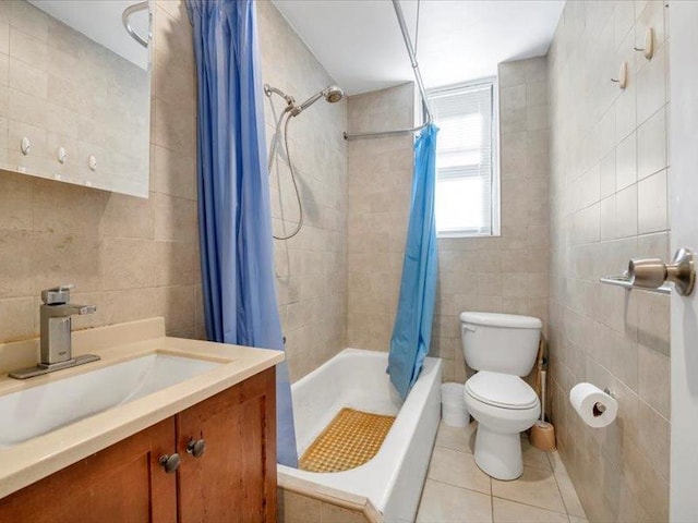 bathroom featuring tile patterned floors, vanity, shower / bathtub combination with curtain, tile walls, and toilet