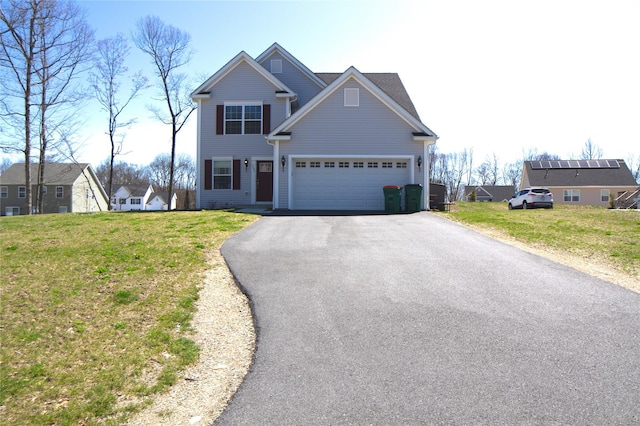 traditional home with an attached garage, driveway, and a front yard