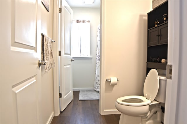 bathroom featuring toilet, baseboards, and wood finished floors
