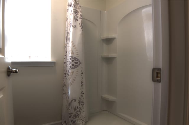bathroom featuring baseboards and curtained shower