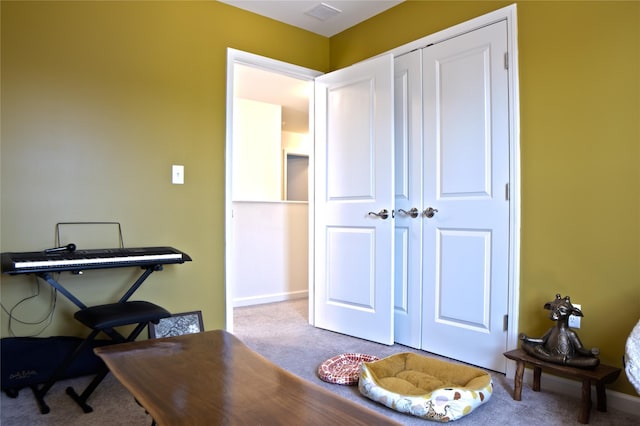 carpeted office space featuring baseboards and visible vents