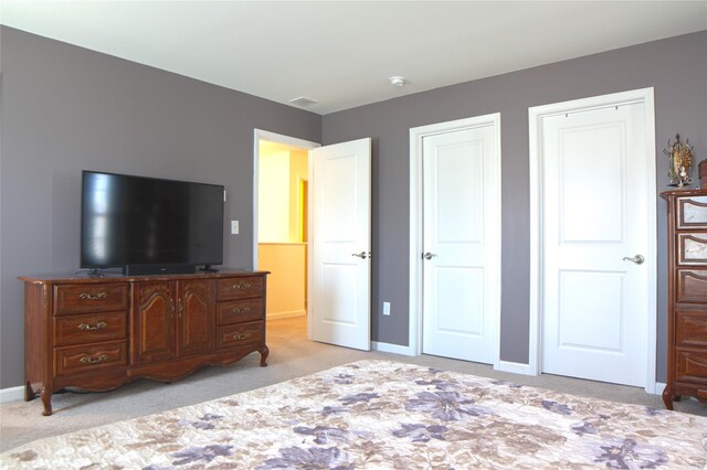 bedroom featuring baseboards, visible vents, and light carpet