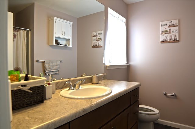 bathroom featuring vanity, toilet, and curtained shower