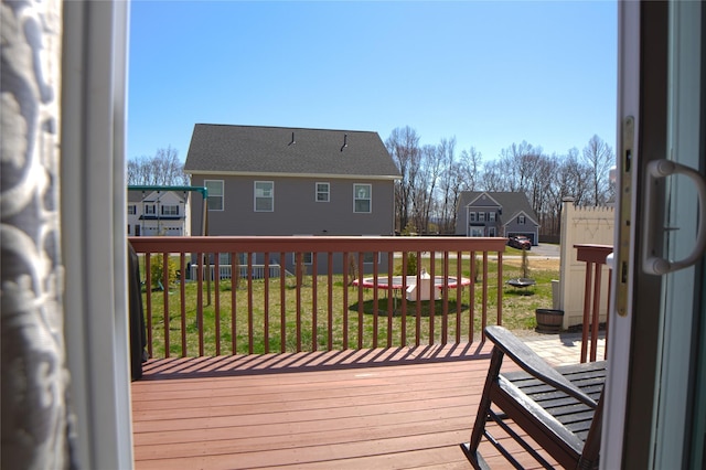wooden terrace with a residential view and a yard