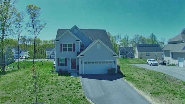 traditional-style house featuring aphalt driveway and a front yard