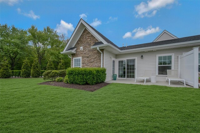 2300 Fox Hill Dr Unit 1101, Baiting Hollow, NY 11933 - rear view of house featuring a lawn, stone siding, and a patio