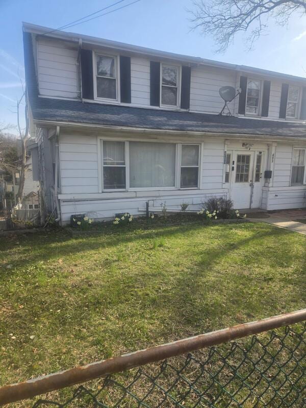 view of front facade with a front yard and fence