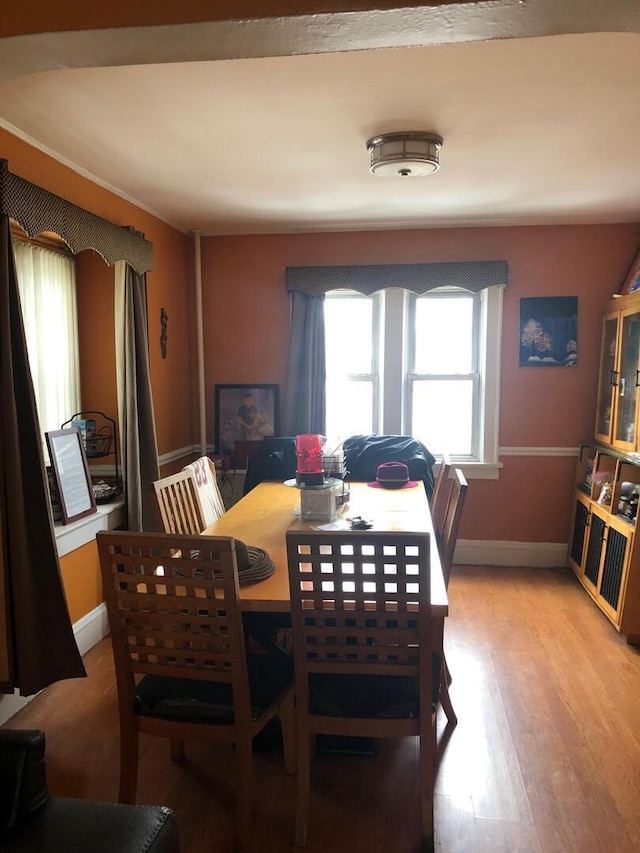 dining area with baseboards and light wood-style flooring