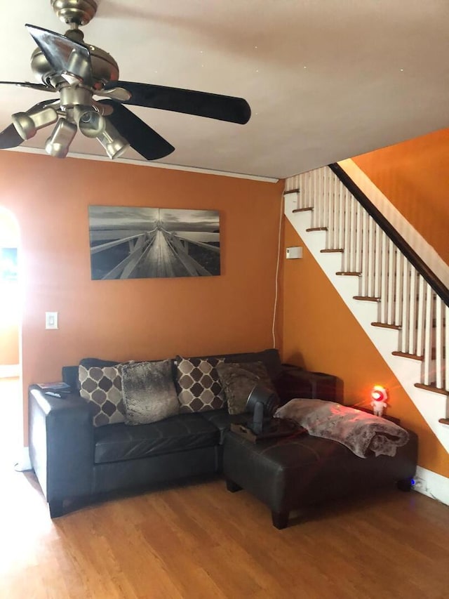 living room with stairway, ceiling fan, and wood finished floors