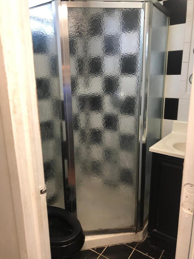 bathroom with tile patterned floors, vanity, and a shower stall