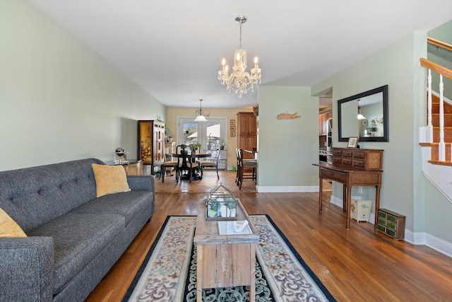 living room with dark wood finished floors, baseboards, and an inviting chandelier