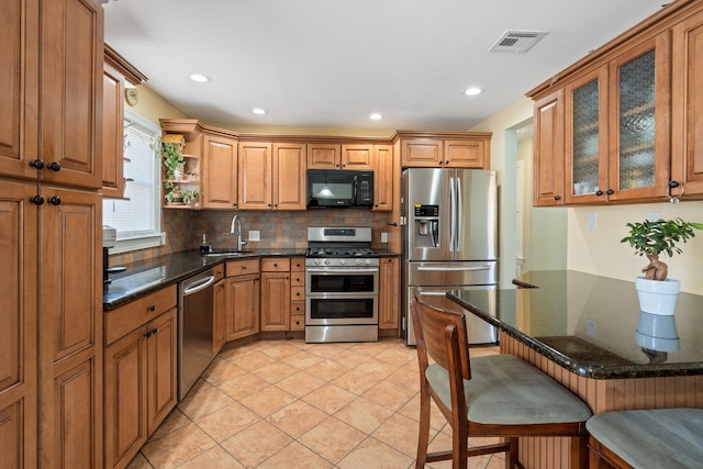 kitchen with a sink, visible vents, backsplash, open shelves, and appliances with stainless steel finishes