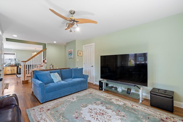 living room featuring stairway, ceiling fan, wood finished floors, and recessed lighting