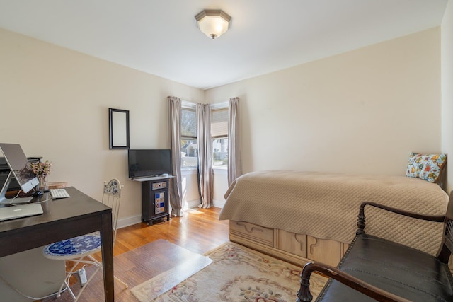 bedroom featuring light wood-style floors and baseboards