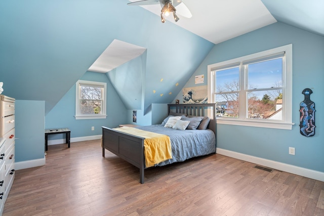 bedroom with ceiling fan, lofted ceiling, baseboards, and wood finished floors