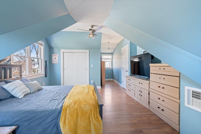 bedroom with lofted ceiling, wood finished floors, a ceiling fan, a closet, and baseboards