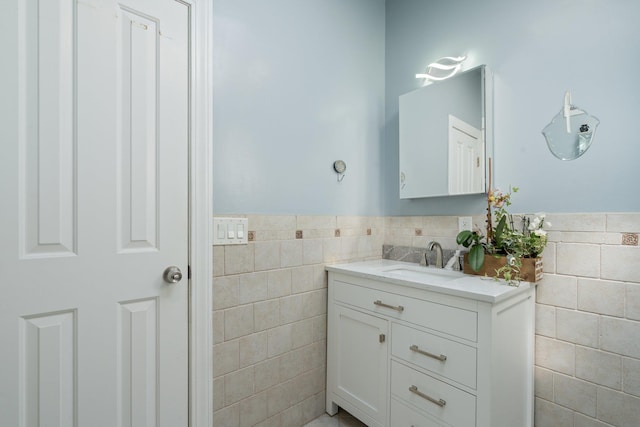 bathroom featuring tile walls, wainscoting, and vanity