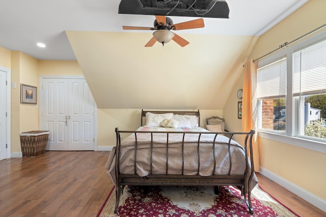 bedroom featuring vaulted ceiling, baseboards, and wood finished floors