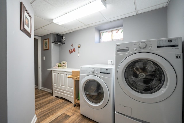laundry area featuring baseboards, wood finished floors, laundry area, and independent washer and dryer