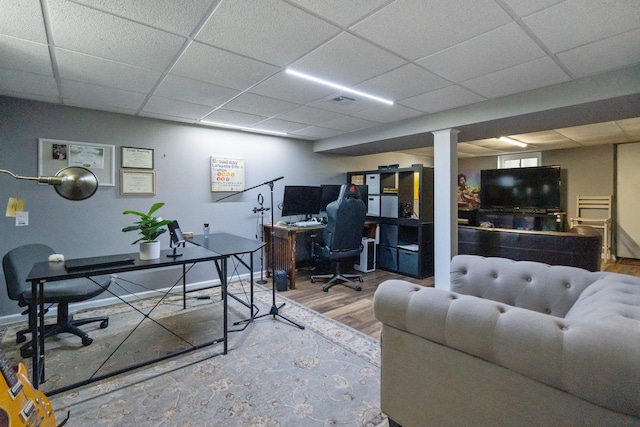 office space with wood finished floors and a drop ceiling
