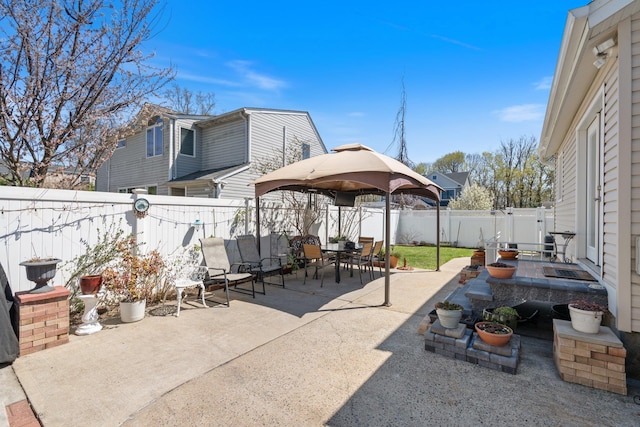 view of patio with a gazebo, outdoor dining space, and a fenced backyard