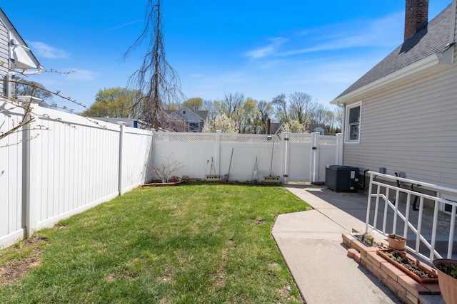 view of yard featuring a fenced backyard, central AC unit, a patio, and a gate