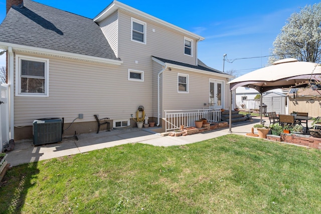 back of house with a patio area, a lawn, central air condition unit, and a shed