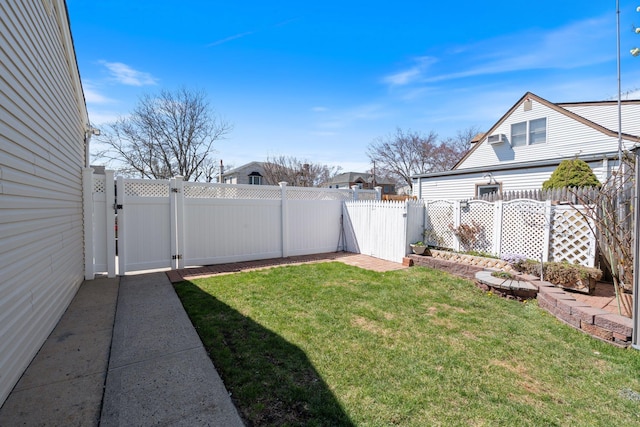 view of yard with a fenced backyard and a gate