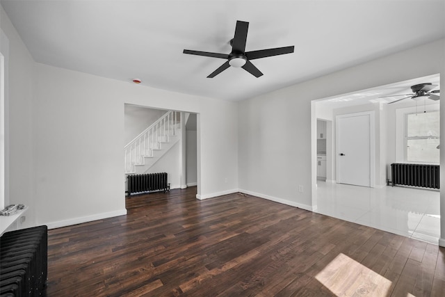 unfurnished living room with ceiling fan, radiator heating unit, and wood finished floors