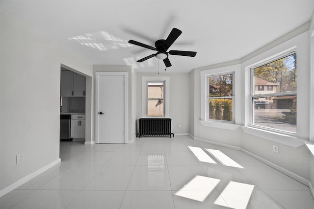 spare room with a ceiling fan, baseboards, a healthy amount of sunlight, and light tile patterned floors