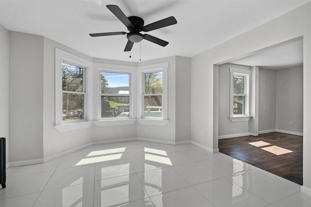 unfurnished room with tile patterned flooring, baseboards, and ceiling fan