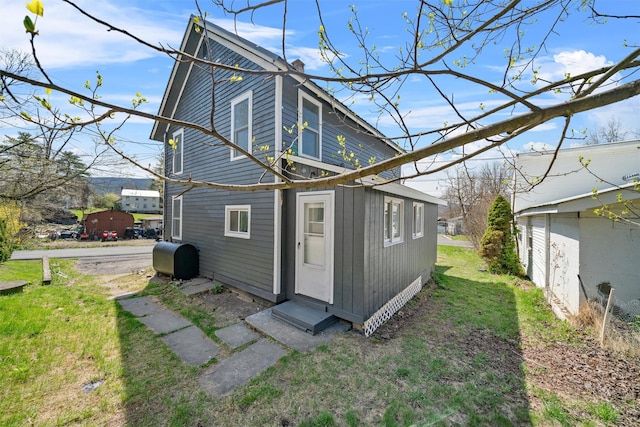 rear view of house featuring a chimney, entry steps, and heating fuel