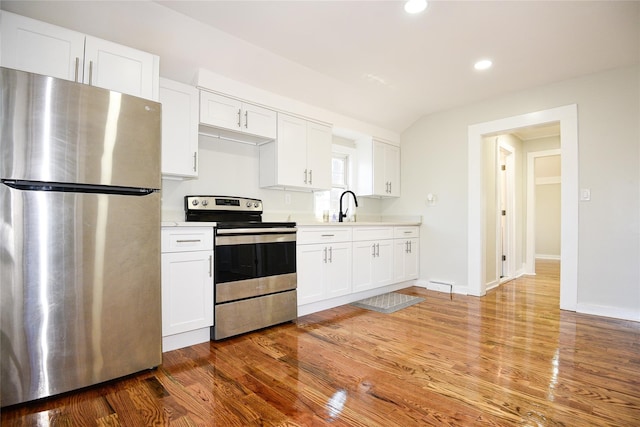 129 Locust Dr, Mastic Beach, NY 11951 - kitchen with appliances with stainless steel finishes, light countertops, recessed lighting, wood finished floors, and white cabinetry