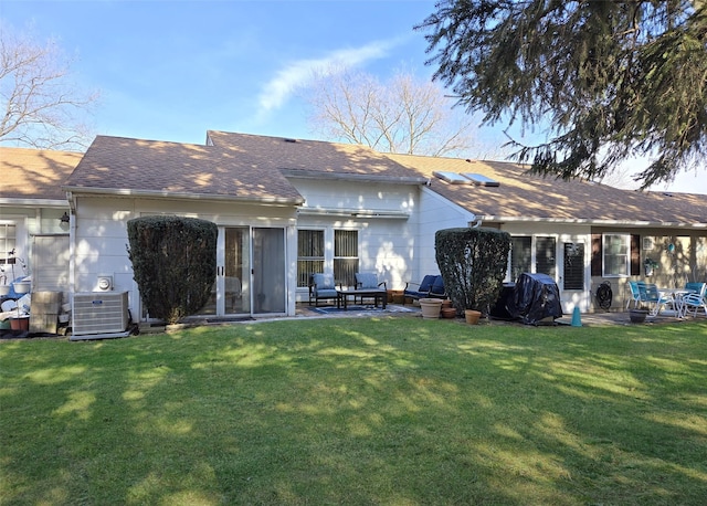 16 Hearthside Dr, Mount Sinai, NY 11766 - rear view of property featuring a shingled roof, a patio area, a lawn, and central AC