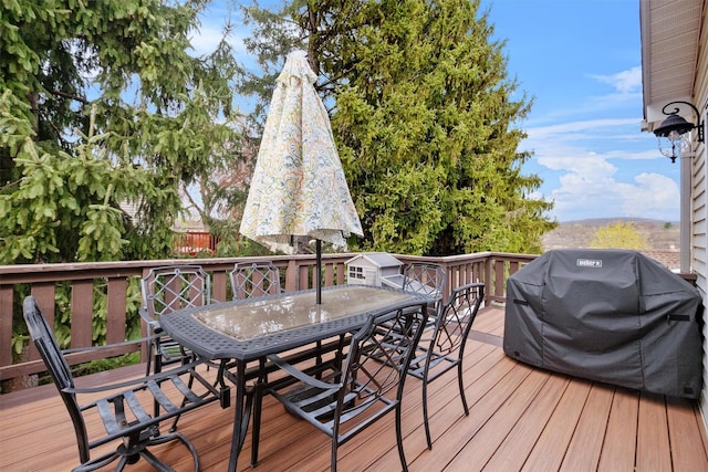 wooden deck with outdoor dining area and grilling area