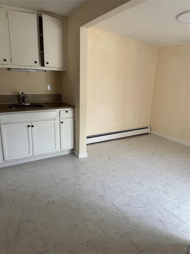 interior space featuring baseboards, a sink, marble finish floor, and baseboard heating