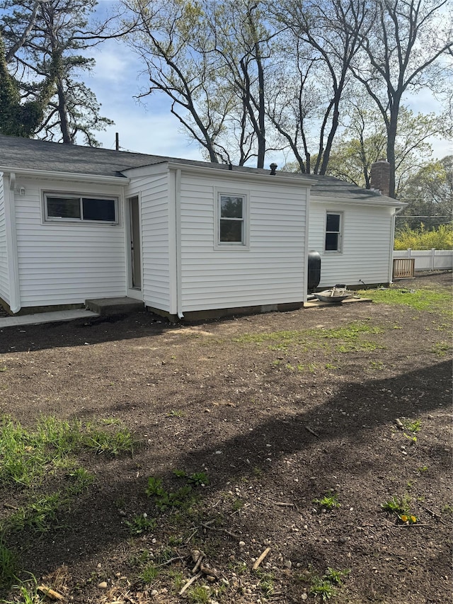 rear view of house featuring fence and a chimney