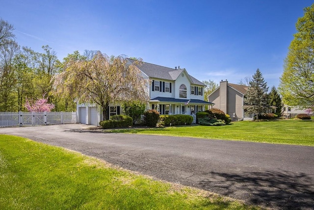 17 Frances Ln, Monroe, NY 10950 - view of front facade featuring a garage, a front lawn, fence, a gate, and driveway