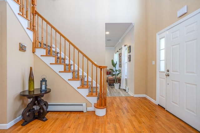 17 Frances Ln, Monroe, NY 10950 - foyer featuring wood finished floors, stairs, crown molding, and a baseboard heating unit