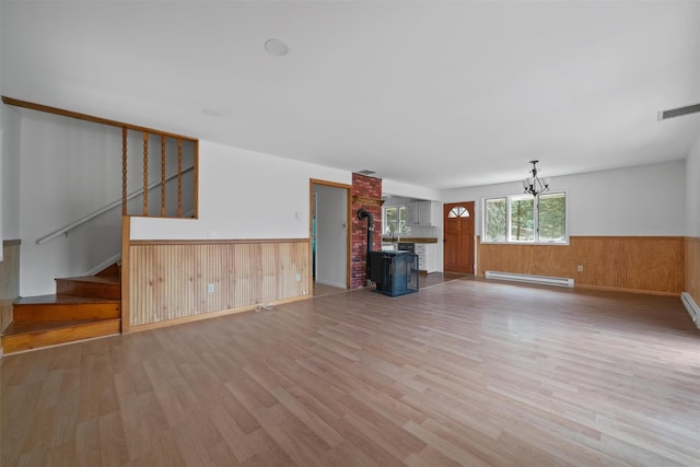 242 Callicoon Center Rd, Jeffersonville, NY 12748 - unfurnished living room featuring wooden walls, light wood finished floors, baseboard heating, and wainscoting